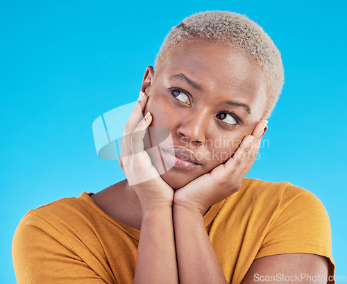 Image of Thinking, sad and black woman with depression, decision or solution on a blue studio background. Person, alone or model with problem solving, thoughts or anxiety with mental health, unhappy or choice