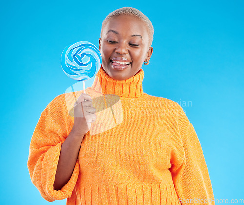 Image of Smile, lollipop and black woman with candy in studio isolated on a blue background. African person, happy and tongue out for sweets, dessert and treats, sugar food and confectionary for eating