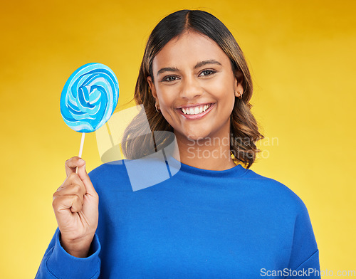 Image of Happy, candy and portrait of a woman, lollipop and positive girl on a yellow studio background. Face, female person or model with sweets, snack and fun with mockup space, cheerful or joy with freedom