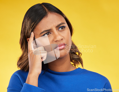 Image of Thinking, confused and young woman in a studio with a dreaming, idea or brainstorming facial expression. Unsure, doubt and Indian female model with a planning or decision face by a yellow background.