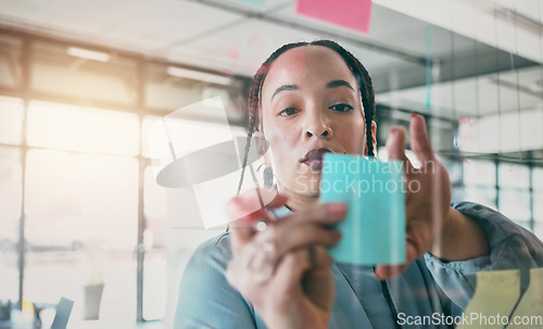 Image of Woman at glass with ideas, moodboard and sticky note for business planning, brainstorming or working process. Thinking, strategy and writing notes for startup proposal on mind map at office workshop.