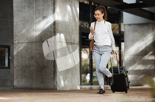 Image of Phone, travel and luggage with a business woman walking in an airport parking lot outdoor in the city. Mobile, suitcase and commute with a young female employee on an international trip for work