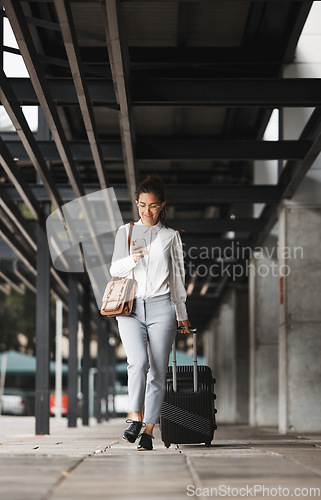 Image of Phone, travel and luggage with a business woman in an airport parking lot walking outdoor in the city. Mobile, suitcase and commute with a young corporate employee on an international trip for work