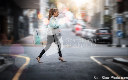 Image of Walking, business and a woman crossing a street in the city while in a rush or late for work. Road, pedestrian and travel with a young female employee on her commute in an urban town for opportunity