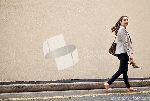 Image of Woman in street, walking at wall with mockup and barefoot, relax and travel for work holiday in city. Space, road and freedom, person on walk with shoes in hands, morning commute and business trip.