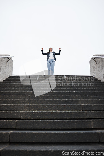 Image of Business woman, stairs and celebration for success, goal or winning in finance career, investment or stock market. Young entrepreneur, winner and fist in air for achievement, pride or lottery in city