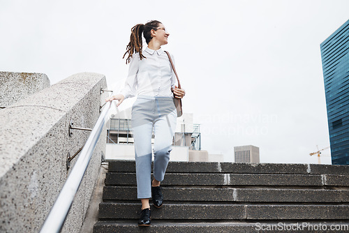 Image of Business, woman and walking on city building steps happy, smile and looking while traveling. Travel, walk and female person smile for commute, thinking and enjoying solo trip in New York outdoor