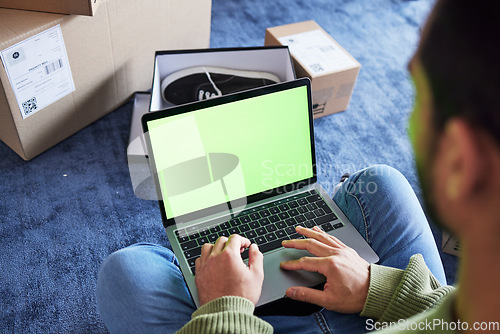 Image of Online shopping, man with laptop, green screen and boxes on floor, shoes and delivery service on digital app. Sale, discount and ecommerce on fashion retail brand website, internet search on computer