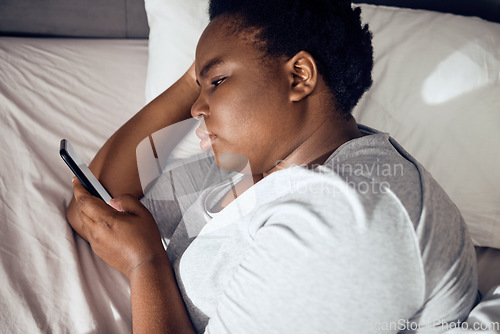 Image of Insomnia, morning or black woman in bed with phone for social media lying in room for addiction at home. Stress, lonely or sad person reading online to scroll on mobile app in bedroom with depression