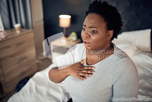 Image of Fear, bedroom and black woman with an anxiety attack or pain in chest from stress. Scary, health and an African girl on a bed with panic, depression or a mental health, mistake or sick for psychology