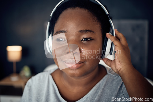 Image of Crying, sad and black woman with headphones for music, sound or audio. Tears, radio and plus size African person listening, hearing and streaming podcast with depression, crisis and problem in home