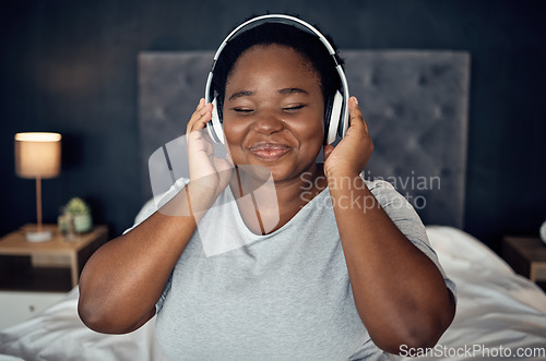 Image of Crying, smile and black woman with headphones for music, sound or audio. Tears, radio and plus size African person listening, hearing and streaming podcast for peace or relax in home bedroom at night