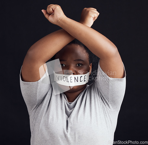 Image of Portrait, freedom and a black woman in protest of domestic violence on a dark background. Censorship, gender equality or empowerment with a serious young female person in studio for human rights