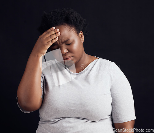 Image of Sad black woman, headache and stress in studio of anxiety, trauma risk and worry on dark background. Frustrated, confused and depressed model with burnout, brain fog and fear, pain and mental health