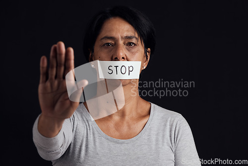 Image of Portrait, stop and palm with a woman in studio on a black background for gender equality or domestic violence. Hand, silence or abuse and a scared female victim with her mouth covered in fear