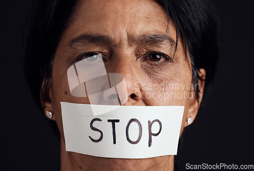 Image of Portrait, stop and silence with a woman in studio on a black background for gender equality or domestic violence. Face, censorship or abuse and a scared female victim with her mouth covered closeup