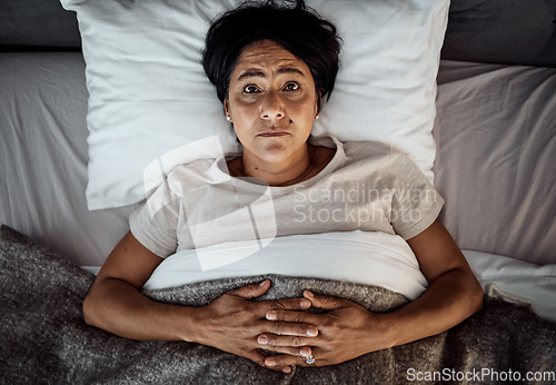 Image of Insomnia, portrait and senior woman in bed from above with menopause, anxiety or stress in her home. Top view, face and elderly female in a bedroom with depression, trauma or mental health crisis