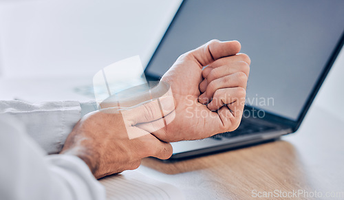 Image of Man, hands and wrist pain from injury, accident or carpal tunnel syndrome on desk at office. Closeup of male person or employee with bad arm ache, sore muscle or tension and overworked at workplace