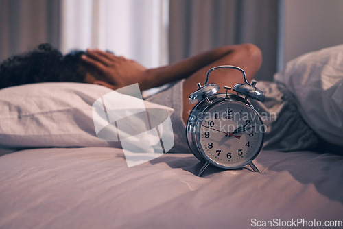 Image of Alarm clock, tired and woman sleeping in bed with exhaustion, depression or insomnia at home. Rest, relax and female person waking up late from a nap in the morning in the bedroom of her house