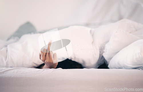 Image of Angry, hand and person with insomnia in bed with a middle finger for morning or waking up, sleeping in bedroom and at home. Hand, show a curse sign and frustrated with sleep problem at night