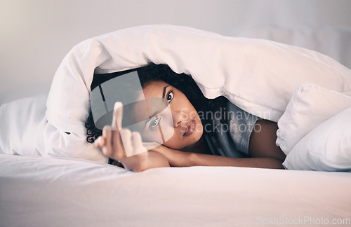 Image of Angry, woman with insomnia and portrait in bed with a middle finger for morning or waking up, sleeping in bedroom or at home. Hand, show a curse sign and frustrated with sleep problem at night