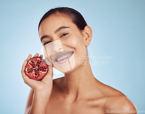 Image of Woman, skincare portrait and pomegranate for natural beauty, cosmetics and facial product or vitamin c benefits. Face of person with red fruits for dermatology or skin care on blue background studio