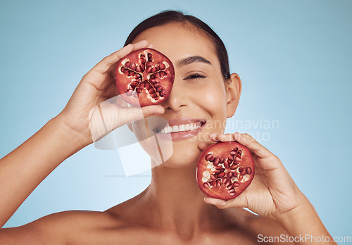 Image of Woman, skincare portrait and pomegranate for eye beauty, natural cosmetics and facial product or vitamin c benefits. Face of person, red fruits and dermatology or skin care on studio, blue background