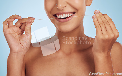 Image of Teeth whitening, flossing and woman, dental and hands, hygiene and grooming with oral care isolated on blue background. Closeup of female model cleaning mouth, health and morning routine in studio