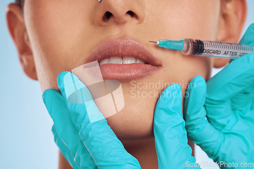 Image of Closeup, woman and plastic surgery with a needle, lip filler and cosmetics against a blue studio background. Zoom, female person or model with injection, dermatology and beauty with medical procedure