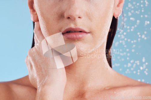 Image of Woman, hands and shower in water for hygiene, cleaning or self love and body care against a blue studio background. Closeup of female person in skincare, rain or wash for cleanliness or grooming