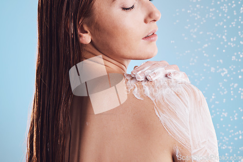 Image of Woman, shower and soap for body hygiene, washing or cleaning against a blue studio background. Female person in relax for soapy scrub, wash or rain drops for skincare, self love or healthy wellness