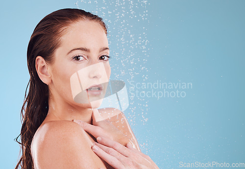 Image of Shower, portrait and skincare with cleaning and woman in studio or blue background for wellness. Girl, cosmetics and water with beauty routine for hygiene or self love with dermatology in bathroom