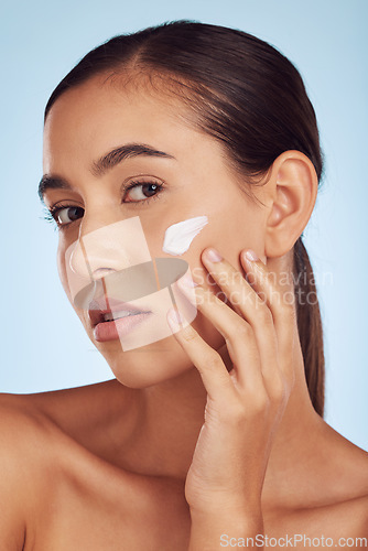 Image of Cream on face, beauty and woman with skincare, cosmetic product isolated on blue background. Portrait, moisturizer and lotion for skin, sunscreen and dermatology, female person and anti aging facial