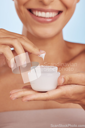 Image of Cream in container, beauty and woman hands with skincare, cosmetic product on blue background. Closeup, moisturizer and lotion for skin, sunscreen and dermatology, female person and anti aging