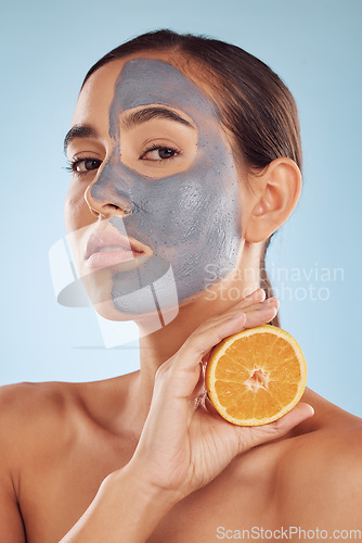 Image of Portrait, face mask and orange with beauty and skincare, eco friendly product and cosmetic on blue background. Charcoal facial, citrus fruit and vitamin c, female model has skin detox and dermatology