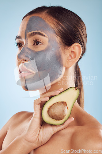 Image of Vision, avocado and mask for beauty with a woman in studio on a blue background for antiaging skincare. Face, facial and detox with an attractive young female holding a fruit for natural treatment