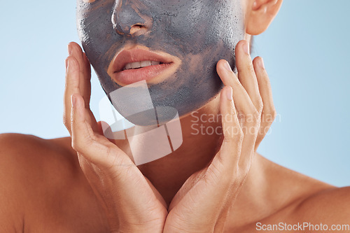 Image of Face mask, charcoal and beauty of woman with facial cosmetic treatment isolated in a blue studio background. Skin, skincare and young female person with clean, hydration and dermatology cream