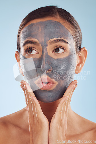 Image of Face mask, skincare and beauty of woman with cosmetic facial treatment isolated in a blue studio background. Skin, charcoal and young female person with clean, hydration and dermatology cream