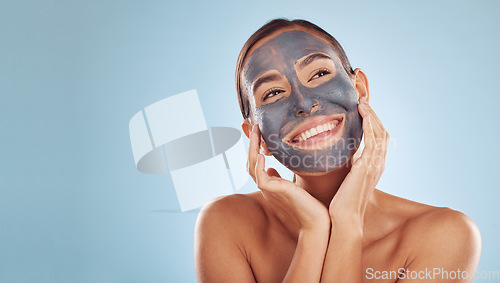 Image of Woman, face mask and thinking of charcoal skincare, natural beauty and cosmetics benefits on studio, blue background. Ideas of person or model for facial collagen, skin care and dermatology on banner