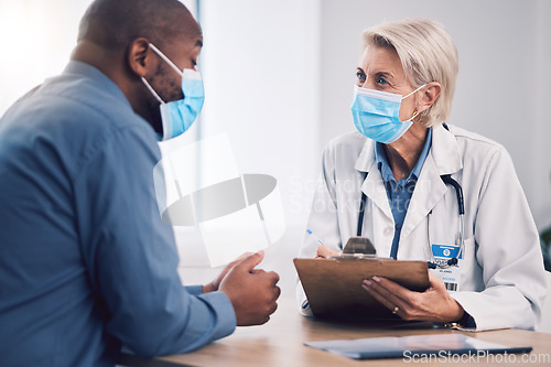 Image of Woman, doctor and clipboard for consultation with patient, checkup or life insurance on desk at hospital. Female person, medical or healthcare expert with face mask consulting customer at the clinic