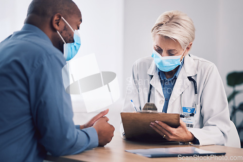 Image of Woman, doctor and writing on clipboard with patient in consultation, checkup or life insurance at hospital. Female person, medical or healthcare expert with face mask consulting customer at clinic