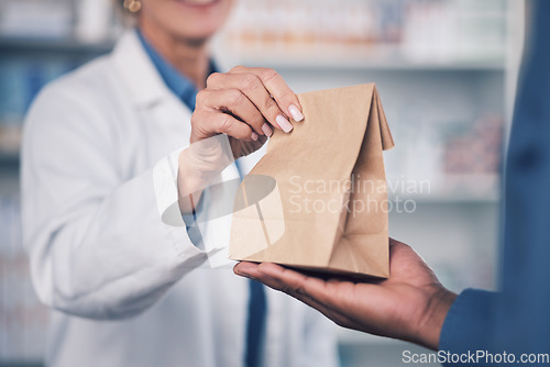 Image of Woman, pharmacist and hands with medication for patient, healthcare or paper bag at the pharmacy. Closeup of female person or medical professional giving pills, drugs or pharmaceuticals to customer