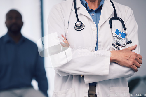Image of Doctor, healthcare consultation and arms crossed in clinic or hospital for support, leadership and management. Closeup of medical person and stethoscope for consulting, health insurance and proud job