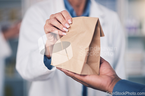 Image of Woman, pharmacist and hands with paper bag for patient, healthcare or medication at the pharmacy. Closeup of female person or medical professional giving pills, drugs or pharmaceuticals to customer