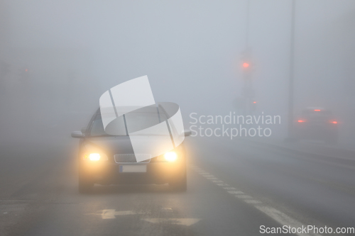 Image of Car Driving on Street in Fog