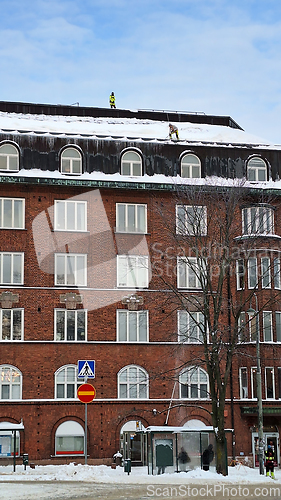 Image of Cleaning Snow from Rooftop in City