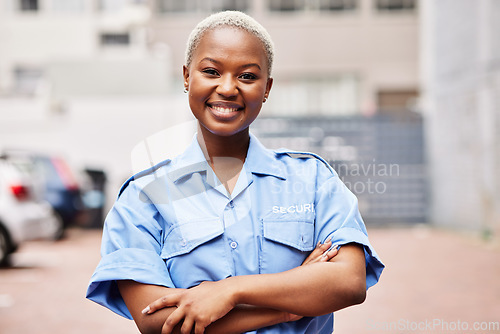 Image of Portrait, black woman and security guard smile with arms crossed in surveillance service, safety and city patrol. Law enforcement, proud bodyguard or happy female police officer in blue shirt outdoor