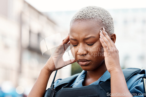 Image of Black woman, police and headache in stress, anxiety or burnout in the city for justice or law enforcement. Tired female person or officer in pain, depression or overworked in street of an urban town