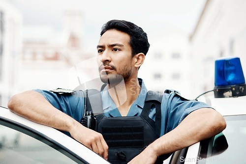 Image of Police, thinking and man officer by a car for an investigation or patrol for law protection in city or urban town. Criminal, safety and legal service guard or security on duty for justice enforcement