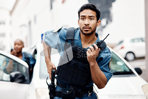 Image of Asian man, police and walkie talkie with gun in city for suspect, communication or reinforcements. Serious male person, security guard or cop radio calling backup for crime in street of an urban town